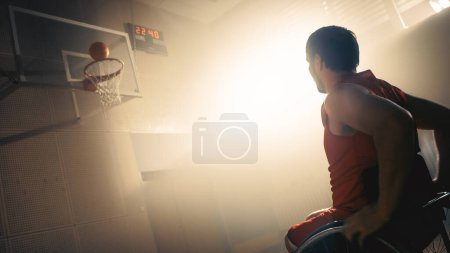 Foto de Jugador de Baloncesto en Silla de Ruedas Vestido con Pelota Uniforme Roja Con Éxito, Anotando una Meta Perfecta. Determinación, inspiración de una persona con - Imagen libre de derechos