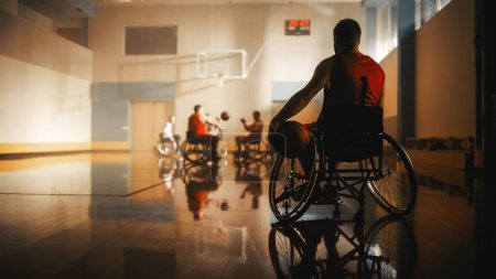 Photo for Wheelchair Basketball Game: Player Wearing Red Shirt Holding Ball Waiting for His Turn. Athlete Watching His Team Play. Determination, Motivation of - Royalty Free Image