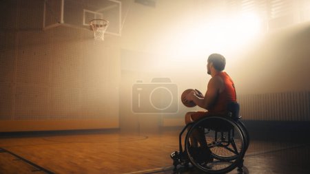 Photo for Wheelchair Basketball Player Wearing Red Uniform Holding Ball, Prepairing to Score a Perfect Goal. Determination, Training, Inspiration of a Person - Royalty Free Image