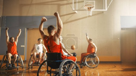 Téléchargez les photos : Équipe gagnante du terrain de basketball en fauteuil roulant Célébrez la victoire, applaudissez et levez la main. Les joueurs rivalisent, tirent, marquent des points de but. Détermination, Compétence de - en image libre de droit