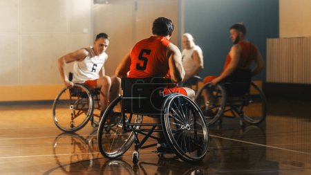Téléchargez les photos : Terrain de jeu de basketball en fauteuil roulant : Joueurs en compétition, dribbler, tirer avec succès, marquer des points de but. Détermination, Compétence des personnes avec - en image libre de droit
