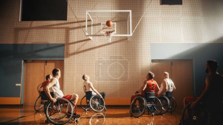 Téléchargez les photos : Jeu de terrain de basketball en fauteuil roulant : Joueurs professionnels en compétition énergiquement, balle dribbler, réussir, tirer avec succès, marquer un parfait - en image libre de droit