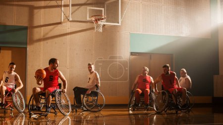 Téléchargez les photos : Terrain de jeu de basketball en fauteuil roulant : Les joueurs en compétition, dribbler, tirer avec succès pour marquer des points de but. Détermination, Compétence des personnes avec - en image libre de droit