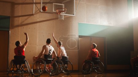 Foto de Juego de baloncesto en silla de ruedas: Jugadores profesionales que compiten, Dribbling Ball, Pasando, Disparando con éxito, anotar una meta perfecta. Determinación y - Imagen libre de derechos