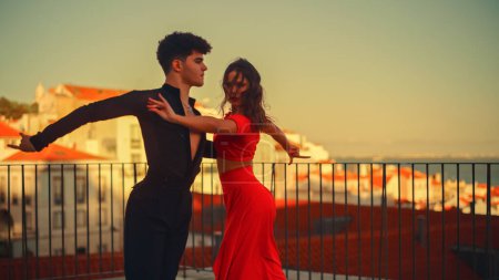Photo for Beautiful Couple Dancing a Latin Dance Outside the City with Old Town in the Background. Sensual Dance by Two Professional Dancers on a Sunset in - Royalty Free Image