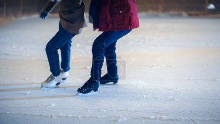 Photo for Romantic Winter Snowy Evening: Ice Skating Couple Having Fun on Ice Rink. Pair Skating Outdoors in a Beautifully Lit Location. Boyfriend and - Royalty Free Image