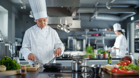 Photo for Restaurant Kitchen: Black Female Chef Cooking Delicious and Traditional Authentic Food, Uses Oil on Pan Getting Ready to Fry Organic Free Range Meat - Royalty Free Image