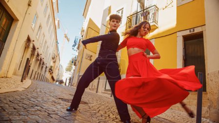 Photo for Beautiful Couple Dancing a Latin Dance on the Quiet Street of an Old Town in a City. Sensual Dance by Two Professional Dancers on a Sunny Day Outside - Royalty Free Image