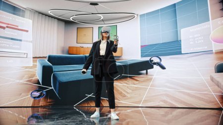 Foto de Diseñador de interiores Usando un software de realidad virtual para diseñar un hogar, probar diferentes colores, mover muebles en un entorno interactivo. Ingeniera femenina usando virtual - Imagen libre de derechos