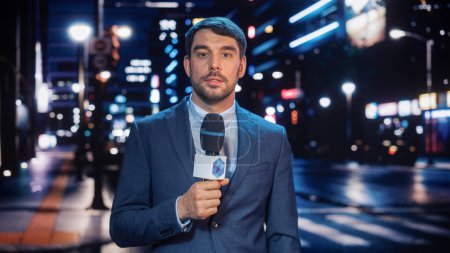 Photo for Anchorman Reporting Live News in a City at Night. News Coverage by Professional Handsome Reporter from a Business District. Journalist Presenting News - Royalty Free Image