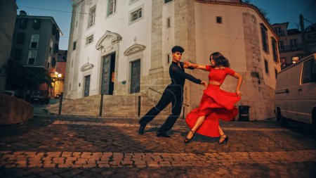 Photo for Beautiful Couple Dancing a Latin Dance on the Quiet Street of an Old Town in a City. Sensual Dance by Two Professional Dancers in the Evening in - Royalty Free Image