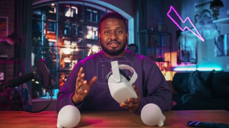 Stylish African American Man Recording a How To Video Review About Modern Virtual Reality Headset (en inglés). Joven hombre negro explicando nuevas características en vivo