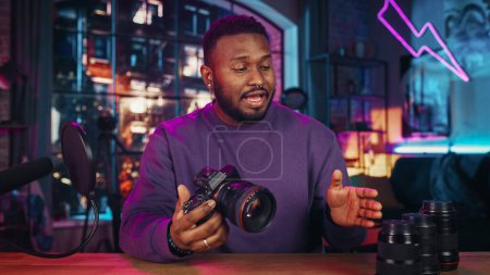 Young Handsome Black Man Recording a How To Video About New Photo Camera and Video Equipment. Entertaining Multiethnic Male Explaining New Features on