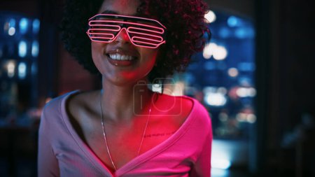 Photo for Close Up Portrait of Diverse Multiethnic Young Latin Female Dancing in Futuristic Neon Glowing Glasses, Having a Party at Home in Loft Apartment - Royalty Free Image