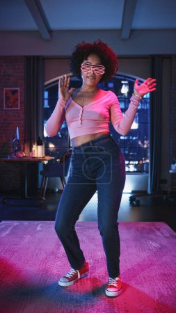 Vertical Screen: Diverse Young Black Latin Female Dancing in Futuristic Neon Glowing Glasses, Having a Party at Home in Loft Apartment. Recording