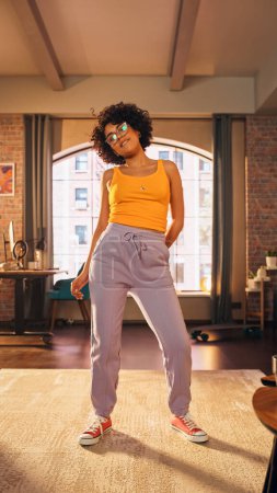 Vertical Screen: Beautiful Young Female in Glasses Record a Dancing Routine on a Smartphone Video for Social Media. Stylish Black Girl in Glasses