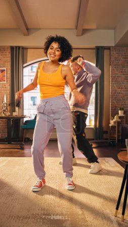 Vertical Screen: Happy Stylish Multiethnic Couple in Casual Outfits Recording a Dance Video from a Party at Home in Loft Apartment. Performing for
