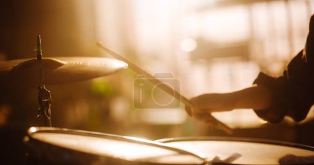 Téléchargez les photos : Close Up Cinematic Portrait of a Young Female Playing Drums, Using Cymbals in a Loft Music Rehearsal Studio Filled with Warm Sunset Light. Rock Band - en image libre de droit