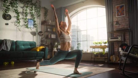 Foto de Young Athletic Woman Exercising, Stretching and Practising Yoga in the Morning in Her Bright, Sunny and Spacious Home Living Room. Healthy Lifestyle - Imagen libre de derechos