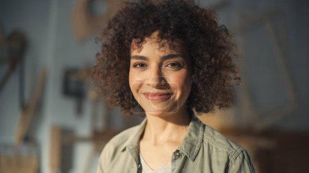 Close Up Portrait of a Beautiful Female Creative Specialist with Curly Hair Smiling. Young Successful Multiethnic Arab Woman Working in Art Studio