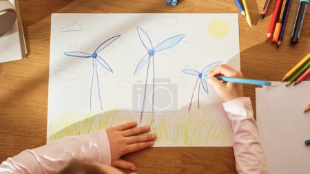 Ansicht von oben: Kleines Mädchen zeichnet wunderschöne Windkraftanlagen, die wie Blumen aussehen. Am sonnigen Tag stellt sich Smart Child unseren Planeten als glücklichen Ort vor