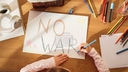 Top View: Little Girl Drawing NO WAR. in Protest against Evil, Greedy People who Bring Only Poverty, Violence and Destruction to Our Beautiful Planet