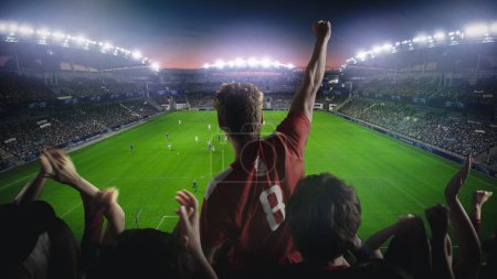 Establishing Shot of Fans Cheer for Their Favorite Team on a Stadium During Soccer Championship Match. Teams Play, Crowds of Fans Celebrate Victory