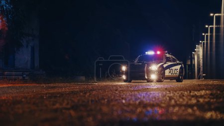 Im Tiefflug ein angehaltenes Polizeiauto mit eingeschaltetem Licht und eingeschalteter Sirene in einer nebligen Nacht. Patrouillierendes Fahrzeug steht bereit und wartet auf Aufträge