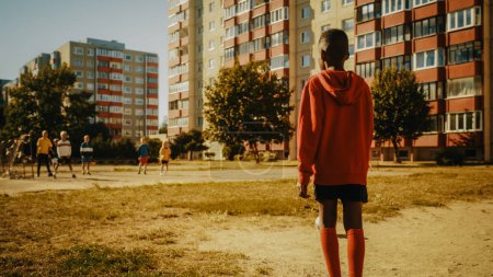 Schwarzer Junge beim Fußballspielen mit Freunden. Multiethnische Kinder beim Fußballspielen in der Nachbarschaft. Spieler feiern das Tor mit