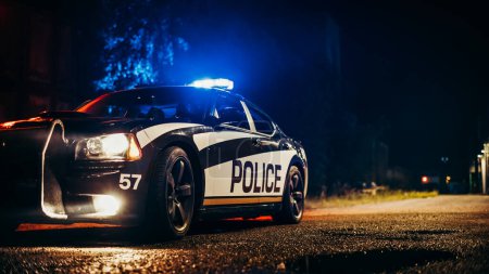Photo for Cinematic Shot Police Car with Working Siren Flashlights Standing in the Middle of Dark City Street. Traffic Patrol Vehicle Ready to Fight Crime - Royalty Free Image