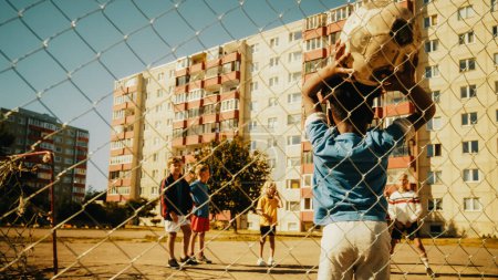 Téléchargez les photos : Young African Boy Throwing the Ball from Offline, Neighborhood Kids Starting to Play Soccer in the Hood. Multicultural Friends Play Football Together - en image libre de droit