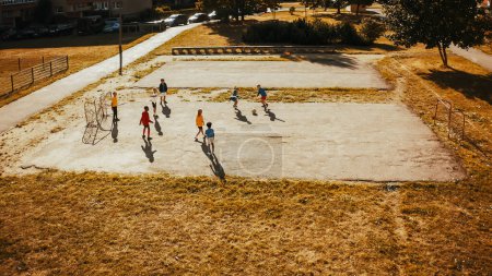 Aerial Shot of Talented Multiethnic Diverse Kids Playing Soccer in Their Backyard on a Sunny Day in Summer. Sporty Boys and Girls Enjoying a Game of