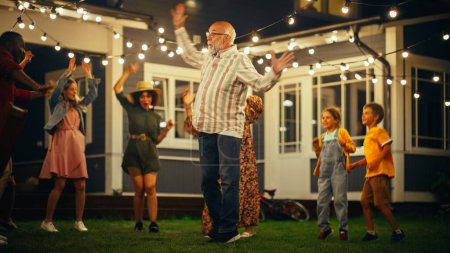 Photo for Active and Healthy Senior Man Dancing Together with Family and Friends at an Evening Garden Party Celebration. Young and Elderly People Having Fun on - Royalty Free Image