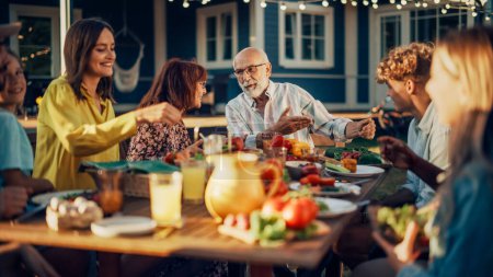 Groupe de personnes multiethniques et diverses qui s'amusent, communiquent entre elles et mangent à l'extérieur. Famille et amis réunis à l'extérieur de leur