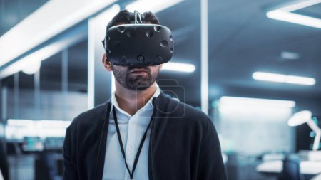 Portrait of a Young Industrial Specialist Wearing a Virtual Reality Headset in a High Tech Industrial Laboratory Facility. Factory 4 Concept and