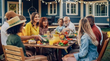 Groupe de personnes multiethniques et diverses qui s'amusent, communiquent entre elles et mangent des repas végétariens lors d'un dîner en plein air. Parents et amis