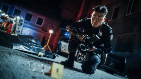 Porträt eines asiatischen Polizisten, der gerichtsmedizinische Fotos von Beweismitteln macht, die neben der Leiche des Opfers am Tatort gefunden wurden