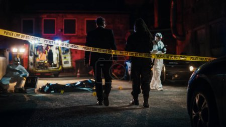 Cinematic Shot: Lieutenant Arriving At a Crime Scene, Crossing the Yellow Tape, Listening to Briefing from First Responder Officer. Detective Checking