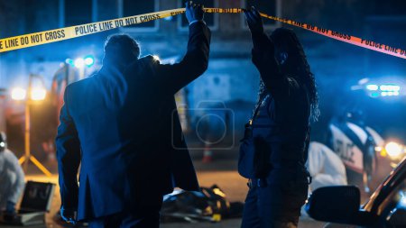 Team of Two Multiethnic Police Officers Working on Profiling a Killer on the Loose. Detectives on Duty at Night Solving Crime to Bring a Violent