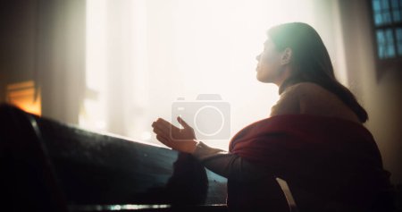 Young Christian Woman Sits Piously in Majestic Church, with Folded Hands She Seeks Guidance From Faith and Spirituality while Praying. Religious