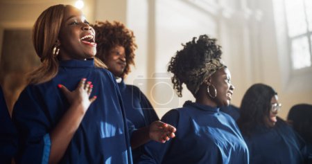 Téléchargez les photos : Black Christian Gospel Singers in Church Clapping and Stomping, Louant le Seigneur Jésus-Christ. Song Spreads Harmony Joy and Faith. Choeur énergétique - en image libre de droit