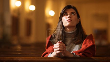 Una devota mujer cristiana se sienta piadosamente en una iglesia, doblando las manos para orar, busca la guía de su fe religiosa y espiritualidad. Espíritu de
