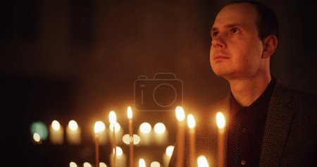 Frommer Christ zündet in der Kirche eine Kerze an, betet und drückt seine Verehrung für Gott aus. Akt des Glaubens und der Hoffnung. Das Licht der Lehre symbolisieren