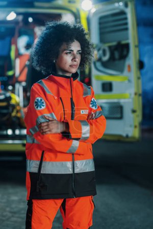 Vertical Photo: Portrait of Beautiful, Multiethnic, Female Paramedic Specialist on Late Night Shift. Heroic Empowering Woman Seriously Looking Away