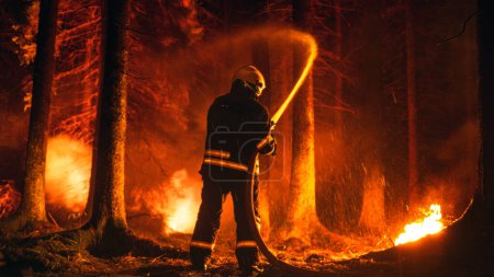Professionelle Feuerwehrleute löschen einen Waldbrand schnell mit Hilfe eines Feuerwehrschlauchs. Feuerwehr rettet Wildland vor unkontrollierbarem Reisigbrand