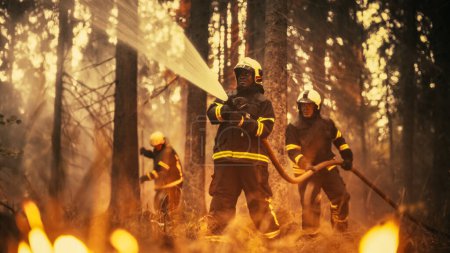 Erfahrener afroamerikanischer Feuerwehrmann löscht einen Wildlandbrand tief im Wald. Profi in Schutzuniform und Helm mit Feuerwehrschlauch