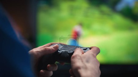 Close Up on Mans Hands at Home, Sitting on a Couch in Stylish Loft Apartment and Playing Arcade Shooter Video Game on Console. Male Using Controller