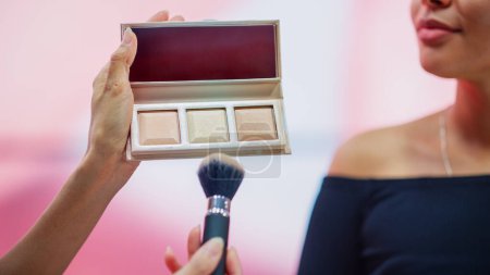 Professionelle Beauty Expert verwendet Blush Contour Palette auf einem Porträt des schönen schwarzen Modells, Werbung für die besten Beauty-Produkte, Kosmetik. Konzept der