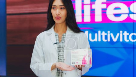TV-Show-Produkt Infomercial: Professionelle Expert Arzt hält Paket-Box mit Health Care Medical Supplements. Schönheit als Vitamin präsentieren