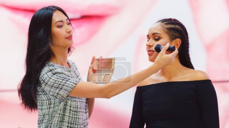 TV-Spot Infomercial: Moderatorin, Beauty-Expertin verwendet Rouge-Konturenpalette auf einem schönen schwarzen Modell, präsentiert die besten Schönheitsprodukte, Kosmetik